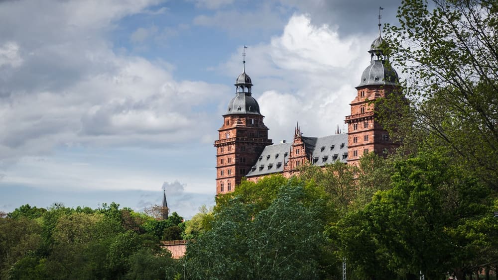 Schloss Johannisburg in Aschaffenburg zwischen Bäumen